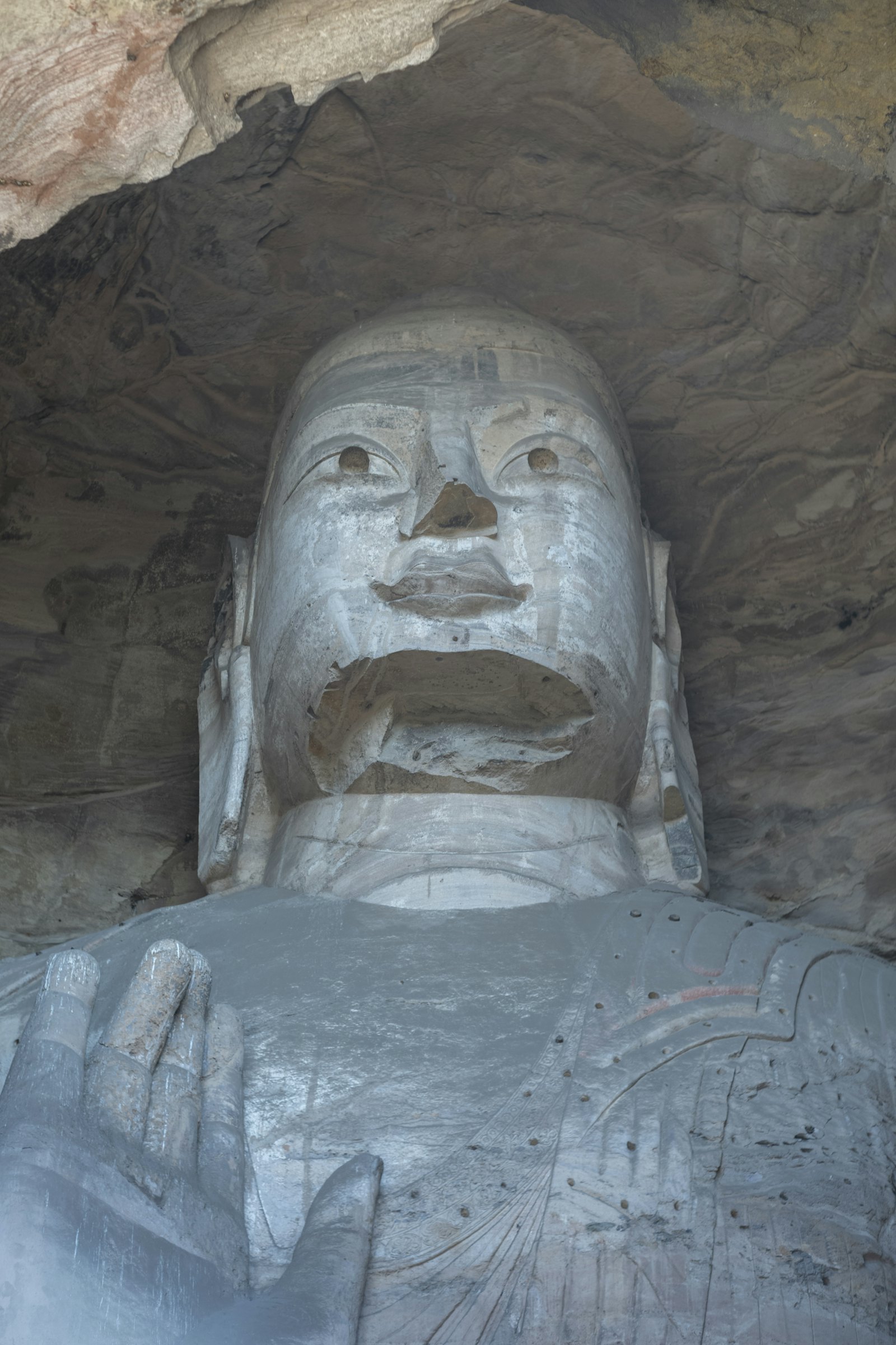 Ancient stone Buddha carved into a cave wall